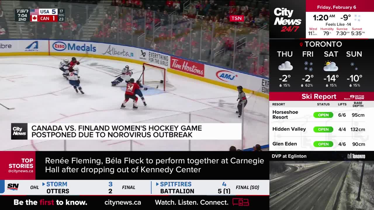 Players in red and white jerseys are battling for the puck near the net. A banner across the ice announces the postponement of a Canada vs. Finland women's h...