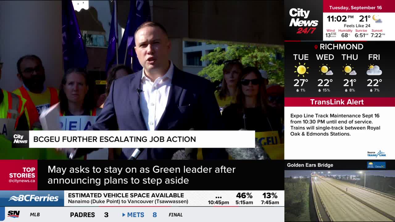 A man in a suit speaks into a microphone, surrounded by a crowd holding signs and purple flags. The CityNews Vancouver graphic at the top of the screen highl...