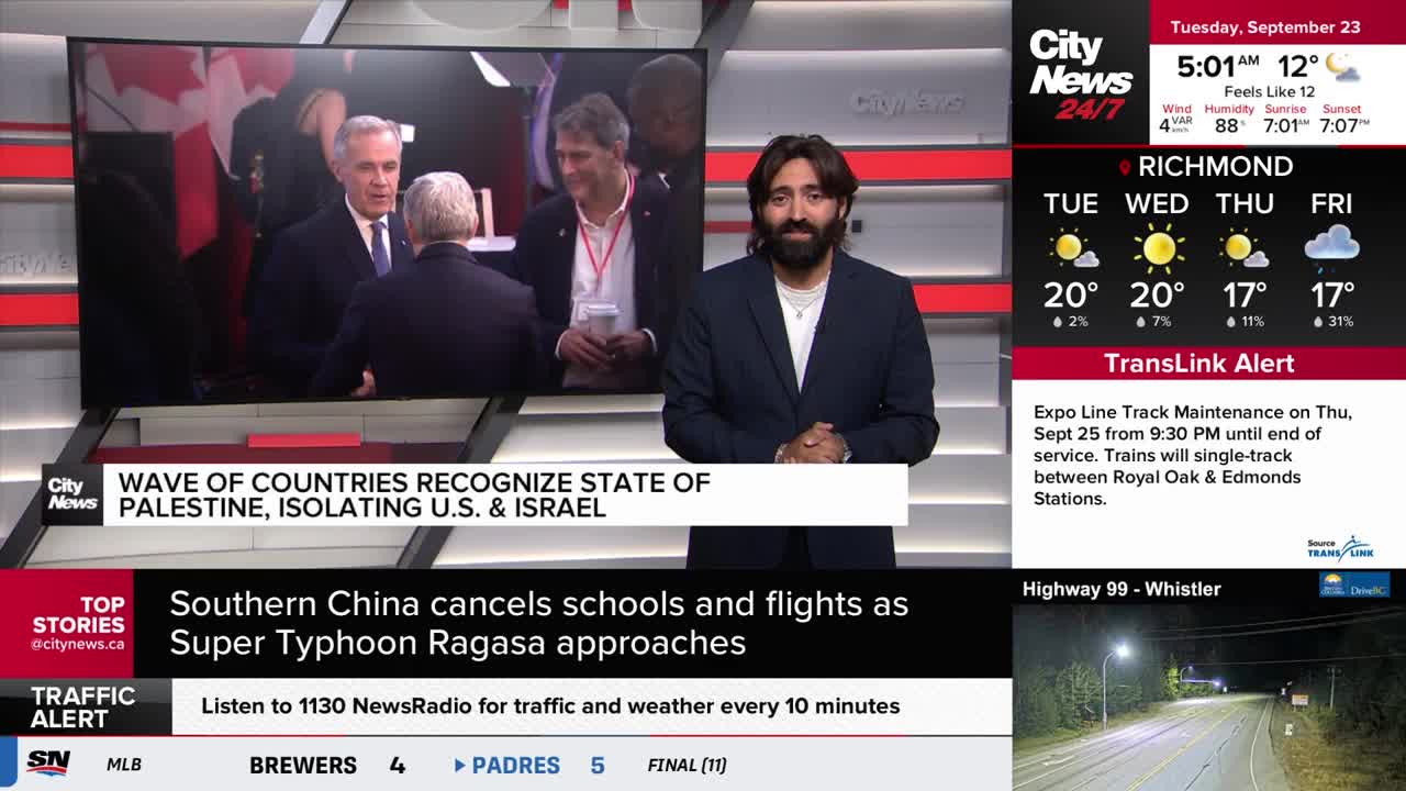 A CityNews Vancouver anchor stands in front of a screen showing a news report. The screen displays a still image of several men in suits, with the Canadian f...