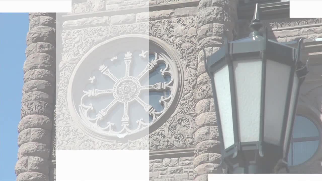 The ornate stonework of the Legislative Assembly of Ontario rises against a clear blue sky. A decorative lamp post hangs nearby, its glass panels reflecting ...