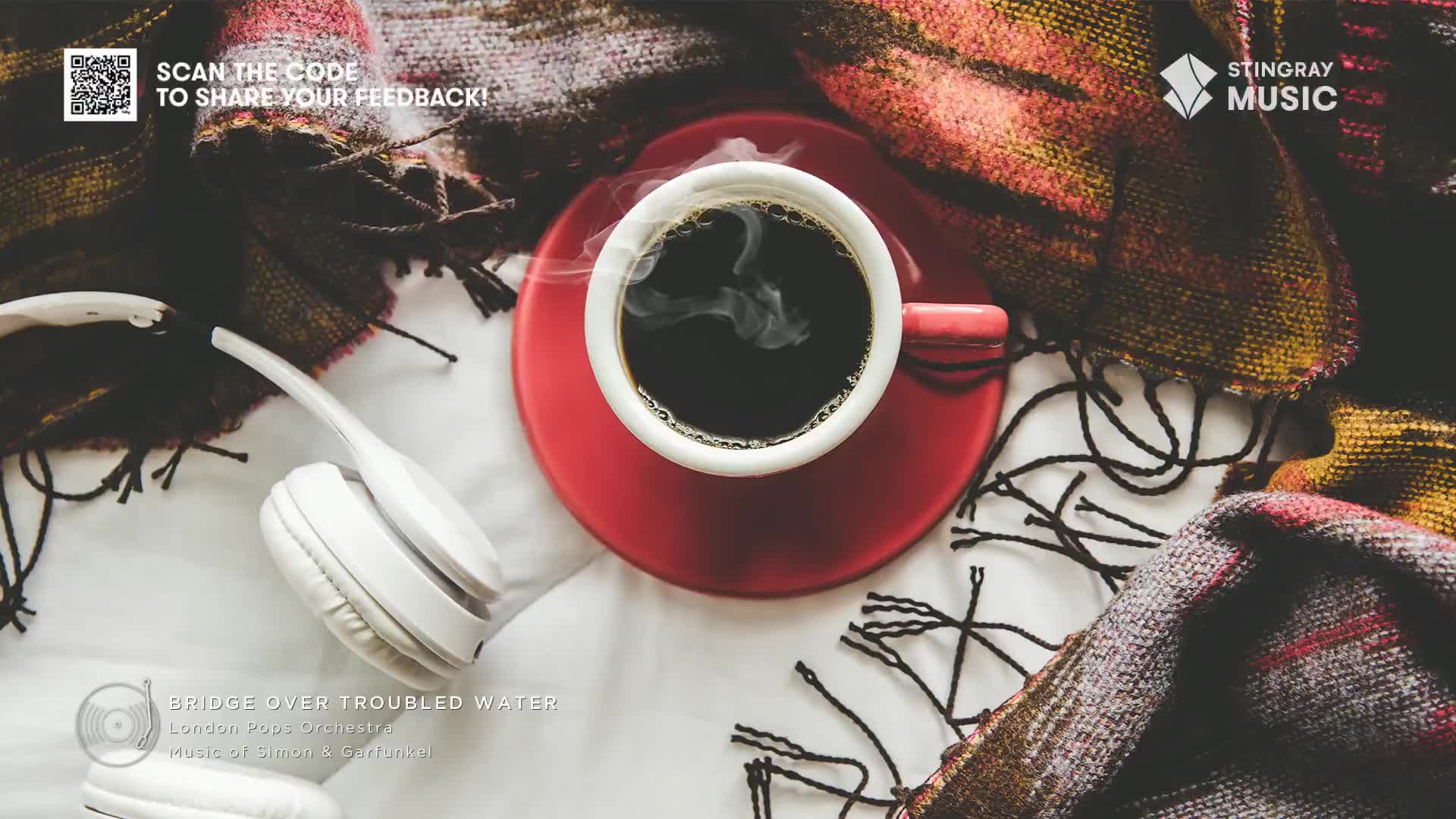 A steaming cup of coffee sits on a red saucer, with white headphones resting nearby. A cozy blanket, perfect for listening to Stingray Easy Listening from Ca...