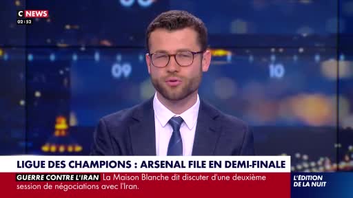A man in a suit and tie speaks directly to the camera, his glasses reflecting the studio lights. Below him, a news ticker scrolls with headlines about the Ch...