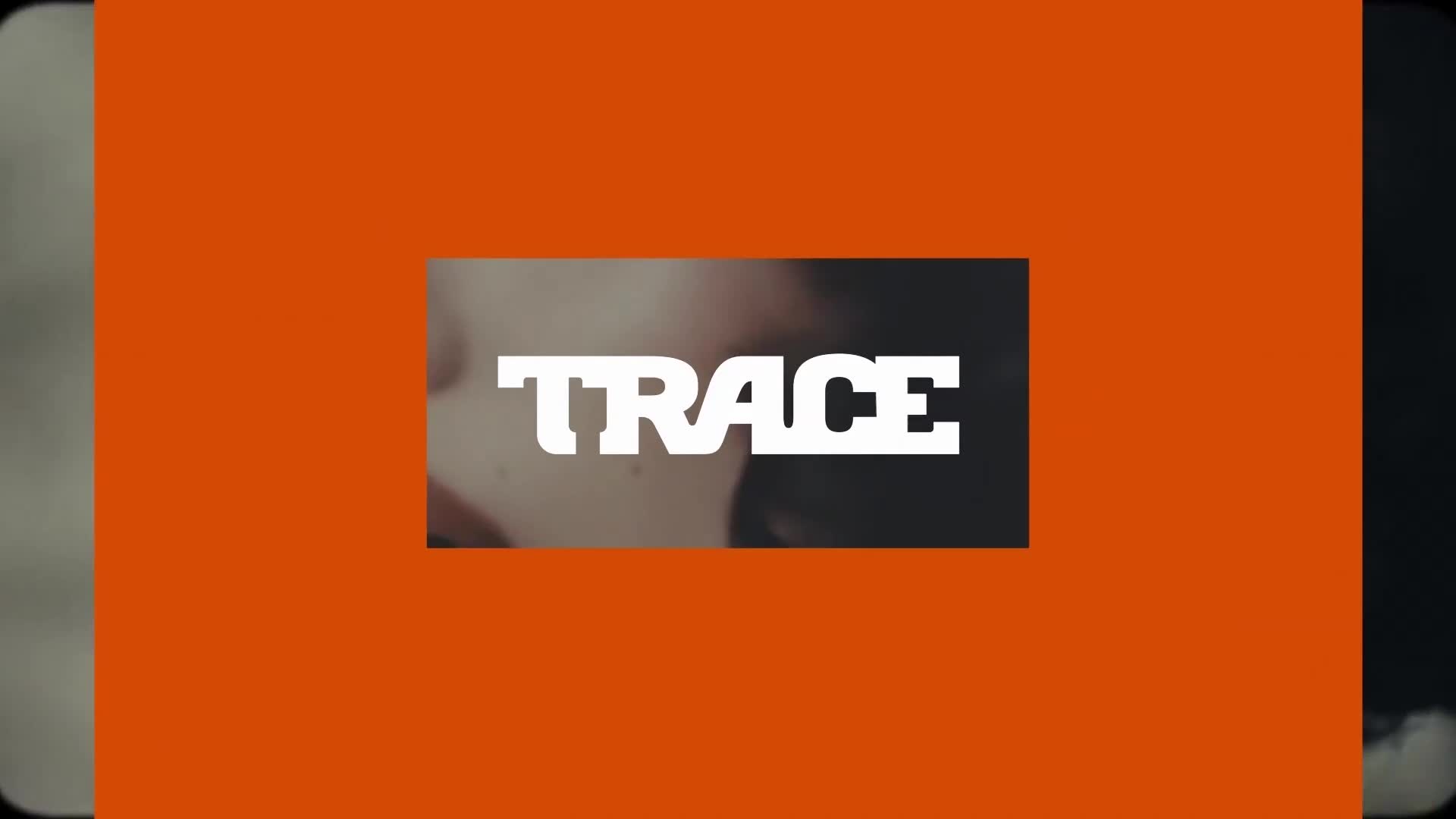 The word "TRACE" is centered in white, bold letters, partially obscuring a close-up of a face. The logo is set against a bright orange backdrop, with darker ...