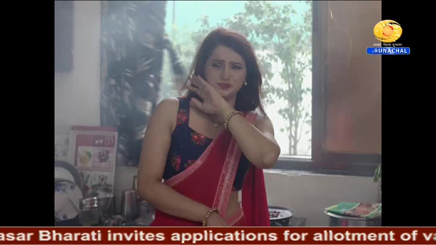 A woman in a red sari and a blue top is touching her face, looking slightly distressed. The DD Arun Prabha logo is in the top right corner, and text about ap...