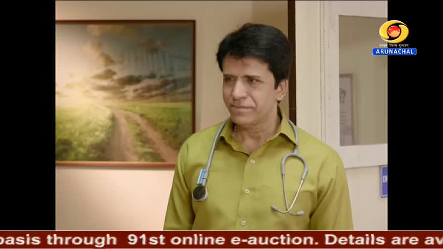 A man in a light green shirt, stethoscope around his neck, gazes slightly to his left. The DD Arun Prabha logo is visible in the upper right corner, and a ne...