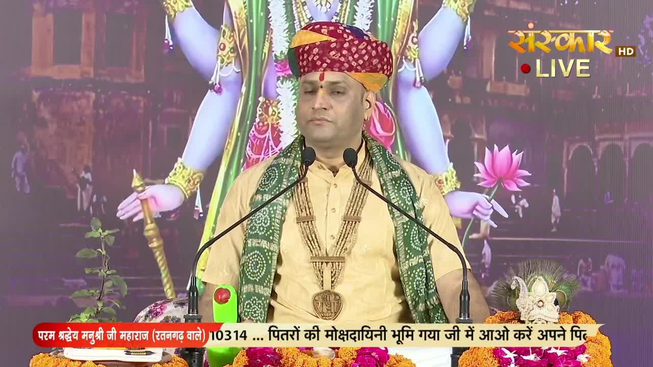 A man in a turban and shawl speaks into two microphones, a gold pendant hanging at his chest. The Sanskar TV logo shines in the corner, and a colorful backdr...