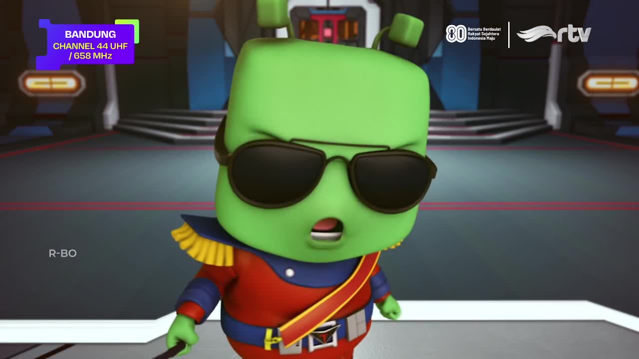 A green cartoon character in a red and blue uniform, wearing sunglasses, seems surprised. The Rajawali TV logo is visible, and the Bandung channel informatio...