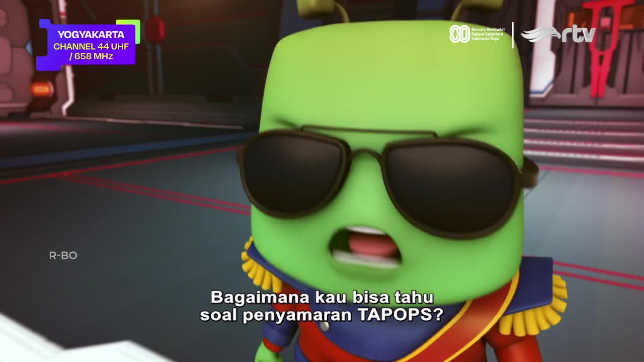 On Rajawali TV, a green, cartoon character with sunglasses is speaking, his mouth open in surprise. The Indonesian text below asks a question about TAPOPS' d...