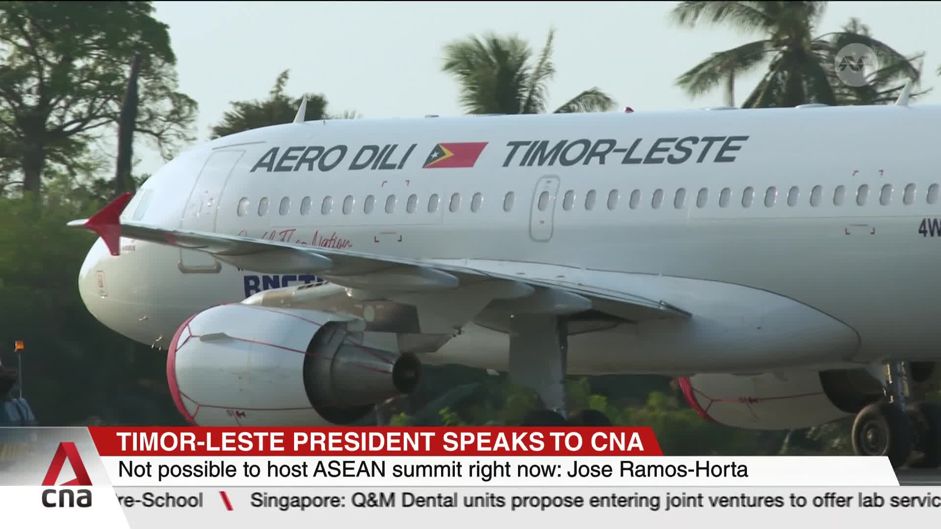 An Aero Dili plane, emblazoned with the Timor-Leste flag, taxis on the tarmac. The CNA International banner reports on the president's statement about the AS...