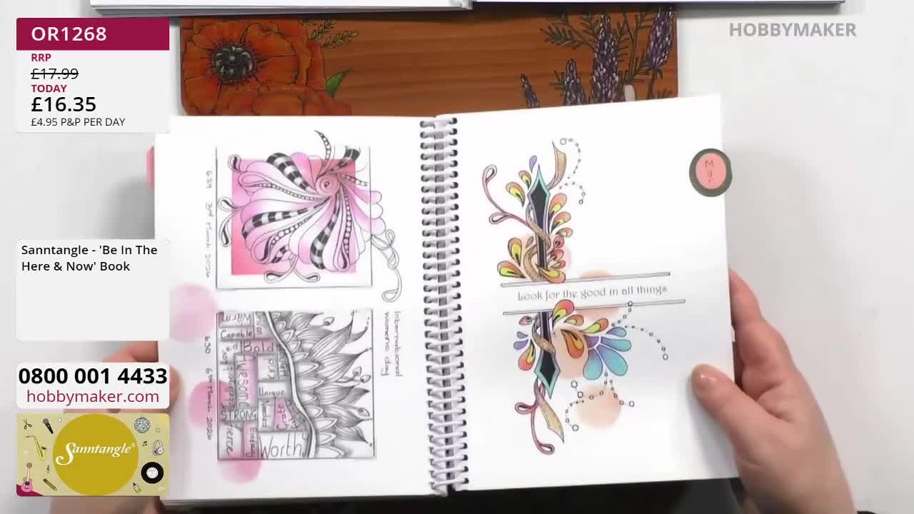 A hand turns the page of a spiral-bound book filled with intricate Zentangle-style art. The open pages display delicate ink drawings, some accented with soft...