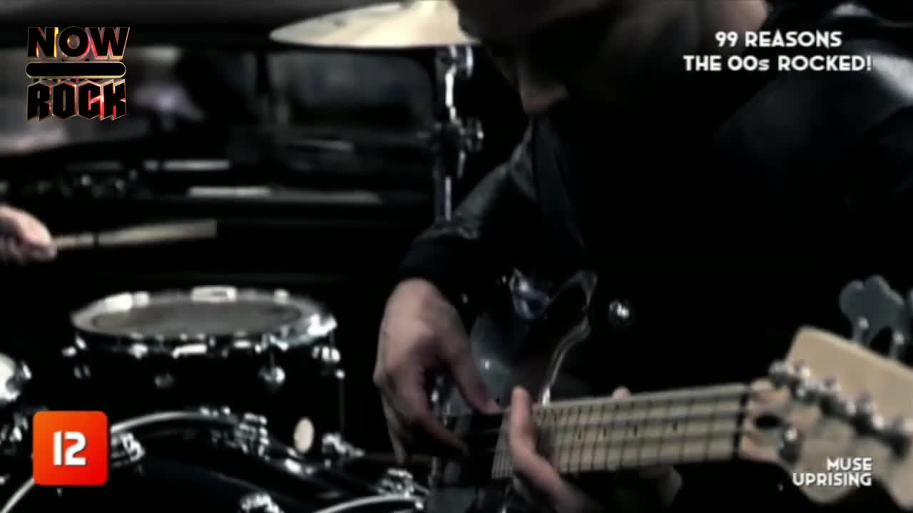 The guitarist's fingers dance across the fretboard, while the drummer's sticks strike the snare. It's a live performance, the energy palpable, with "Muse Upr...