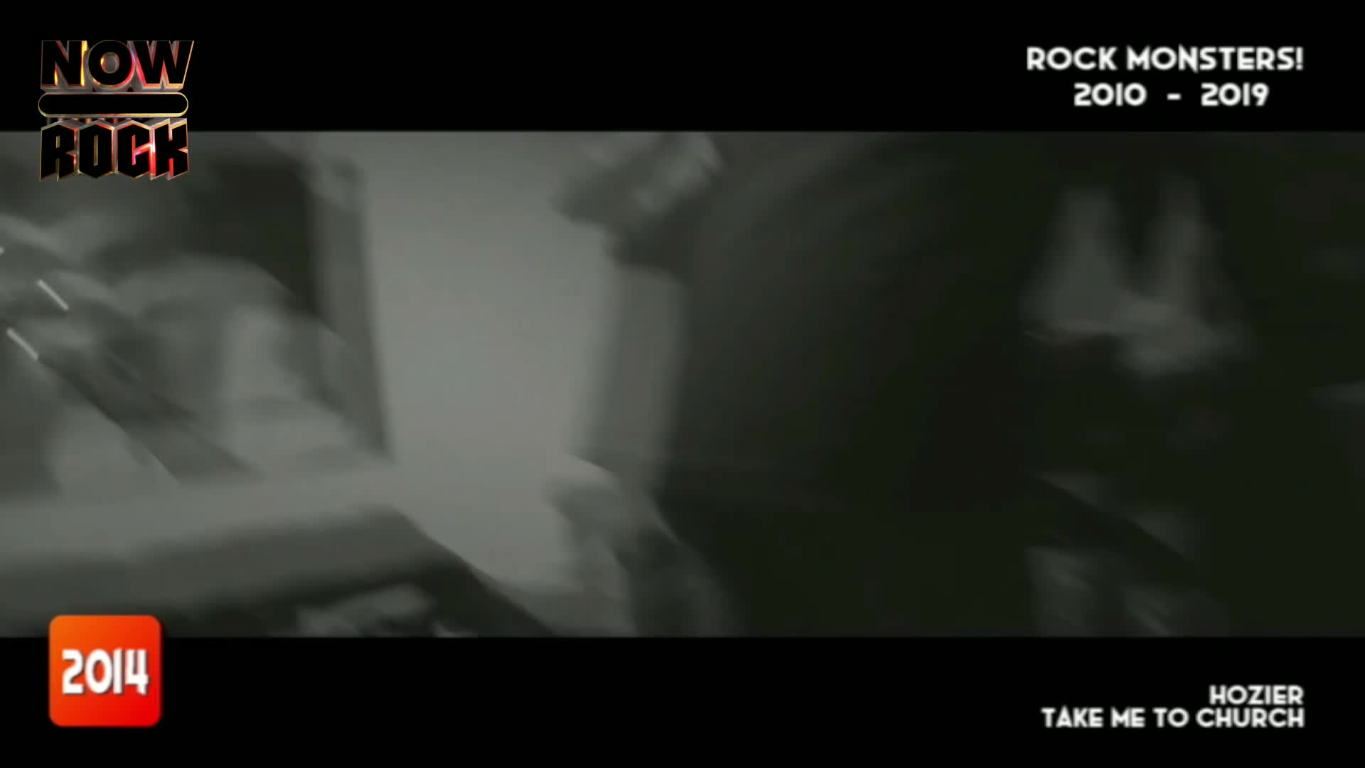 A figure with a guitar is moving quickly, the image blurred from the motion. The black and white video is playing on what looks like a NOW Rock compilation.