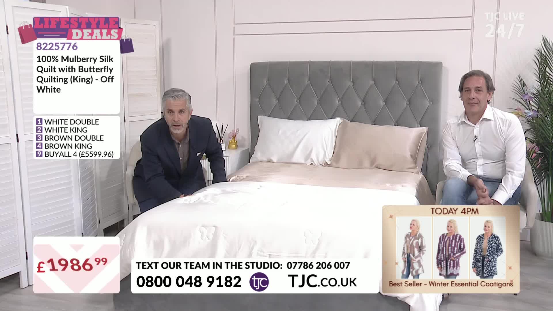 A man in a suit is smoothing a large, white quilt on a bed, while another man sits nearby. The TJC studio is set up with a bed and a display of products for ...
