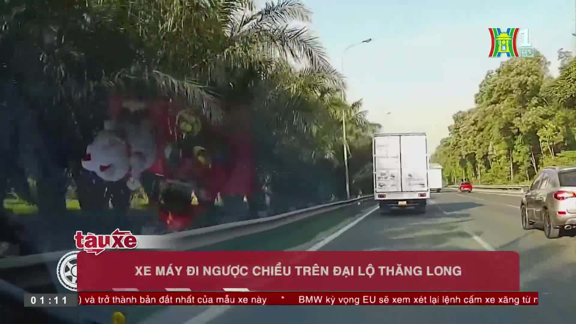 A motorcycle, partially obscured by roadside foliage, is traveling in the wrong direction on the highway.  The HanoiTV1 graphic identifies the location as Đạ...